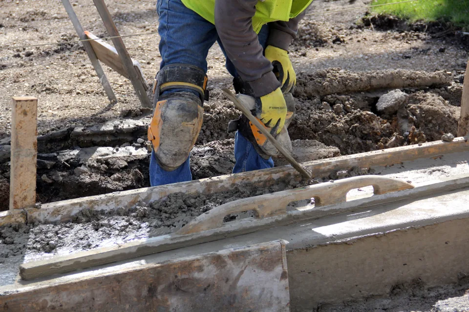Close view of a concrete finishing tool and newly placed material